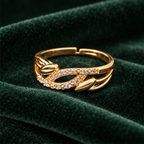 Ananta Leaf Infinity Sparkle Gold-Tone Ring on a forest green velvet backdrop