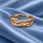 Ananta Leaf Infinity Sparkle Gold-Tone Ring on a dusty blue satin backdrop