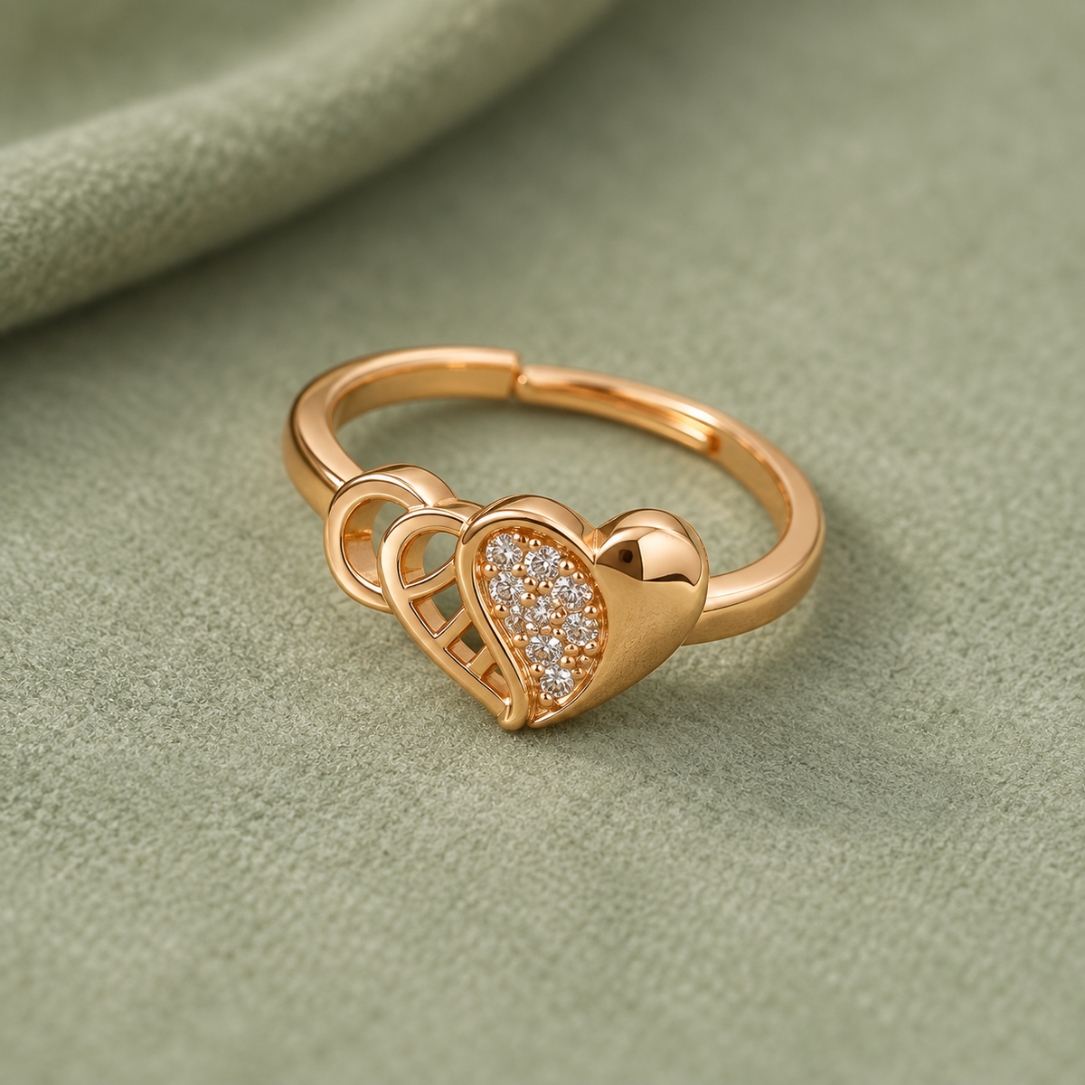 Dilruba Interlocking Heart Rose Gold-Tone Ring on a sage suede backdrop
