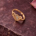 Dilruba Interlocking Heart Rose Gold-Tone Ring on a plum stone backdrop