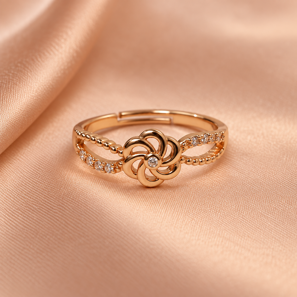 Gulnaar Pinwheel Floral Rose Gold-Tone Ring on a champagne satin backdrop