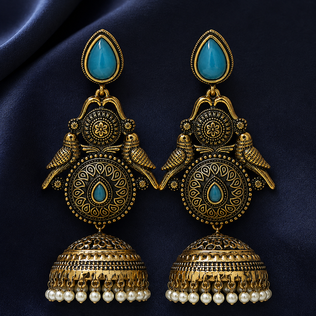 Mayur Neel Antique Peacock Jhumka Earrings on an indigo satin backdrop