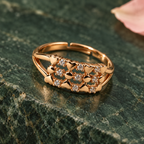 Meher Floral Lattice Rose Gold-Tone Ring on an emerald stone backdrop