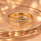 Meher Staggered Sparkle Gold-Tone Ring on a champagne glass backdrop