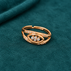 Naina Sparkle Rose Gold-Tone Crossover Ring on a teal suede backdrop