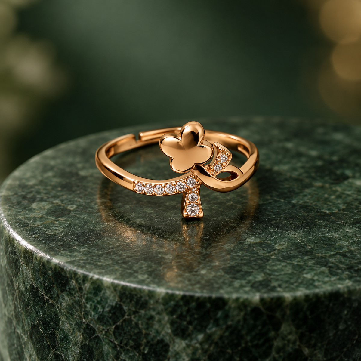 Titli Sparkle Butterfly Ribbon Rose Gold-Tone Ring on a forest green stone backdrop