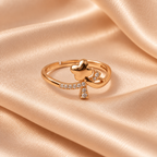 Titli Sparkle Butterfly Ribbon Rose Gold-Tone Ring on a champagne satin backdrop